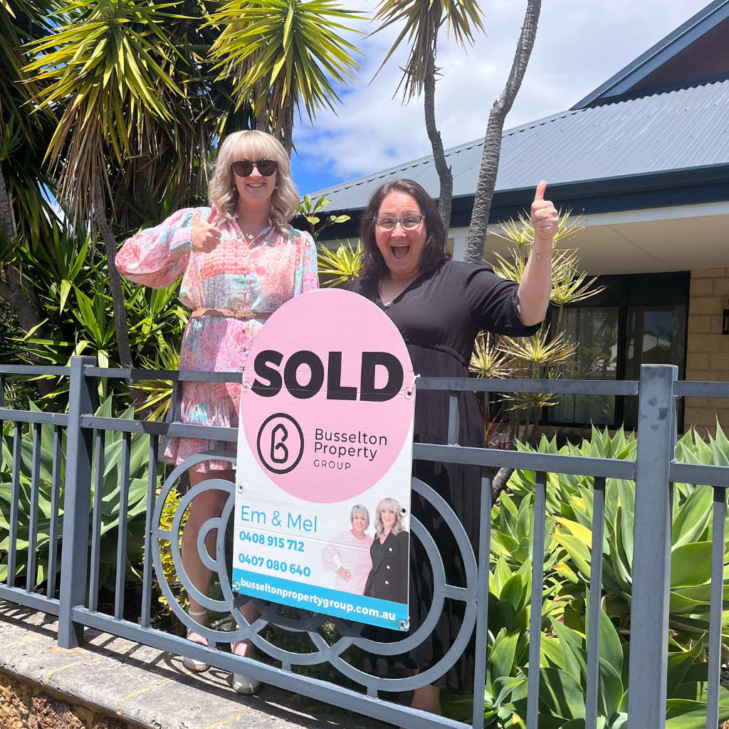 Emma Borinelli with a happy seller and their sold sign.